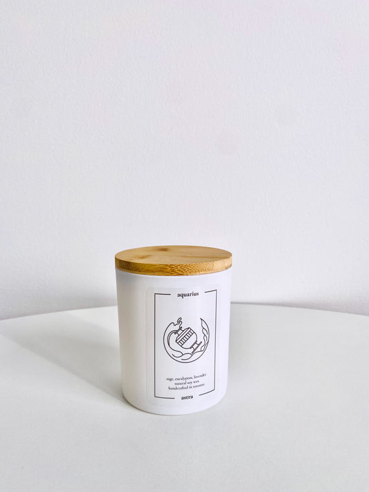 An Aquarius candle, depicting water flowing from a jug, scented sage, eucalyptus and lavender