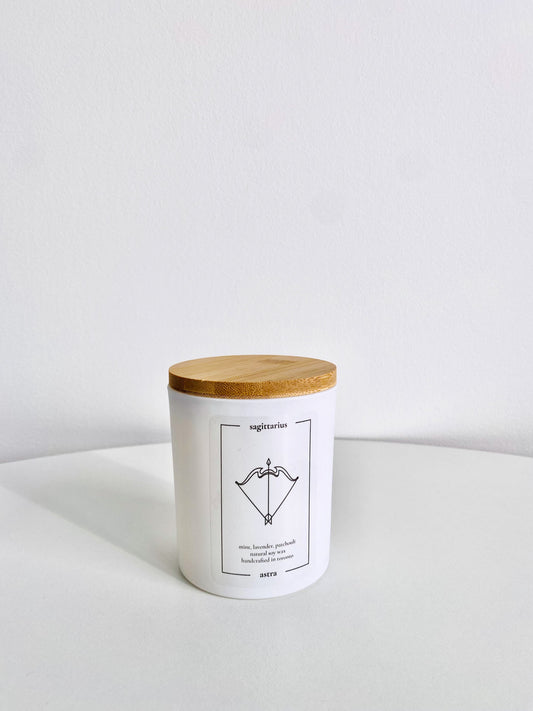 A Sagittarius candle, depicting an archer's bow, scented mint, lavender and patchouli